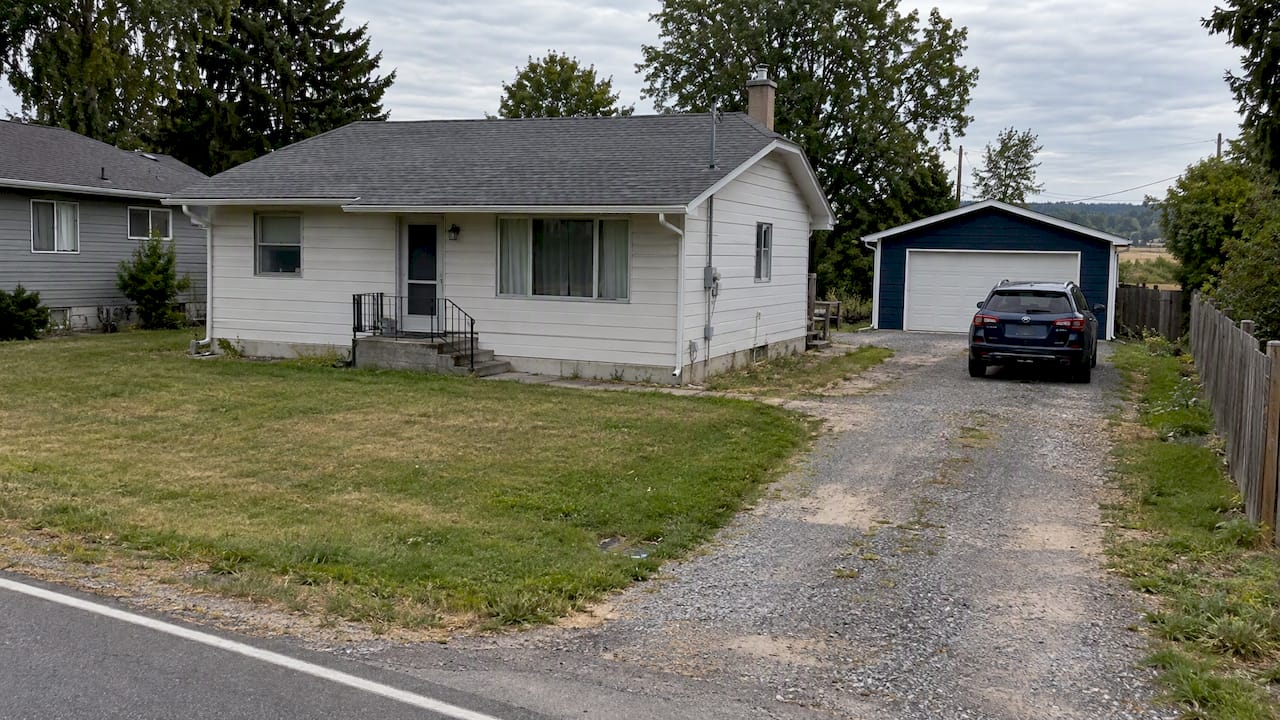 Detached garage with long driveway and yard