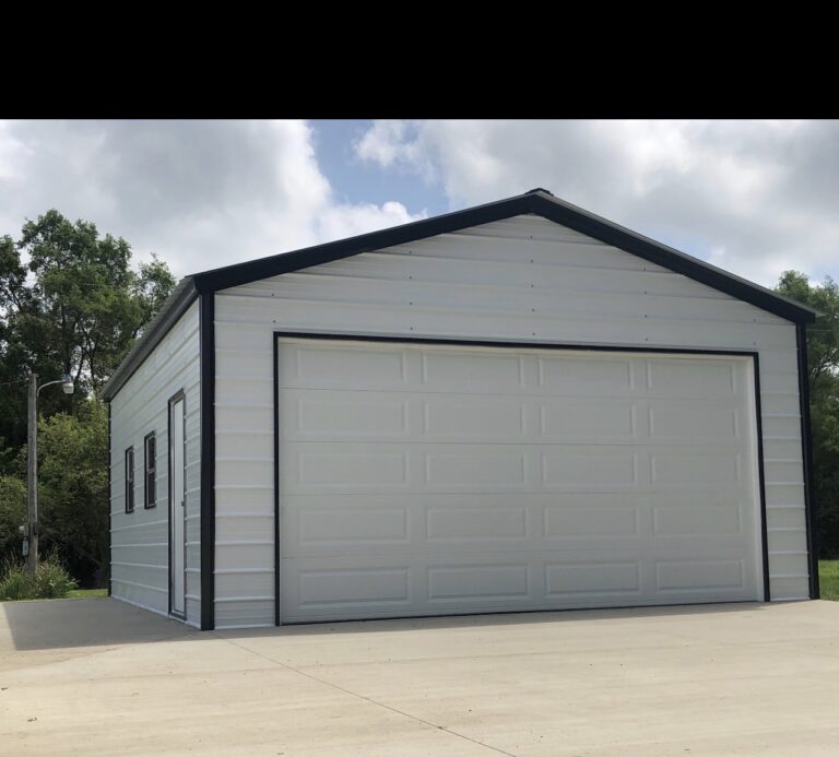 Gray steel garage with a white roll-up door and concrete apron