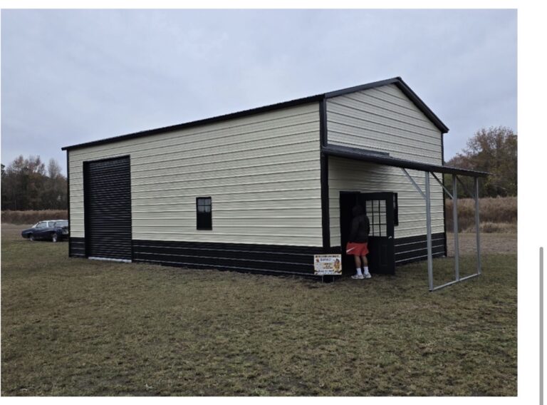 Two-story cream metal building with black trim and a lean-to