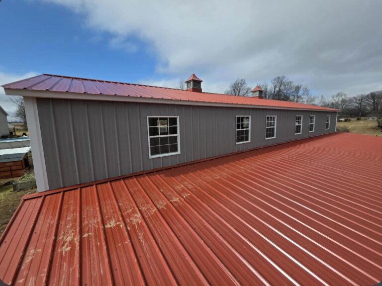 Red metal roof on a gray steel building seen from above