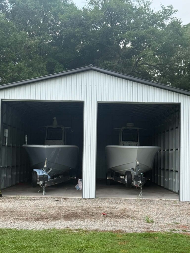 White steel garage with two bays sheltering boats on trailers